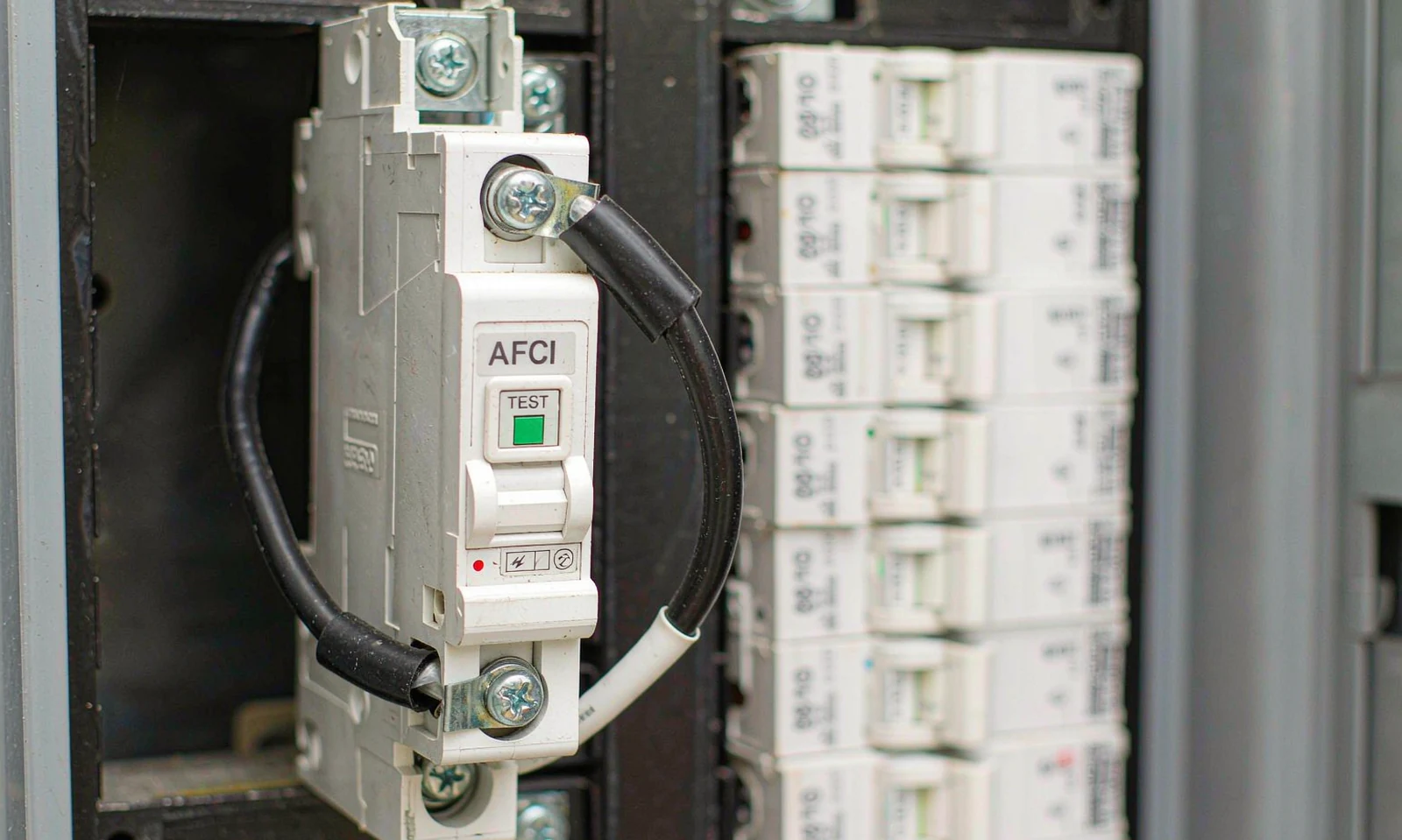 Arc fault breaker installed in a load centre panel, with the TEST button and neutral pigtail visible on the device face